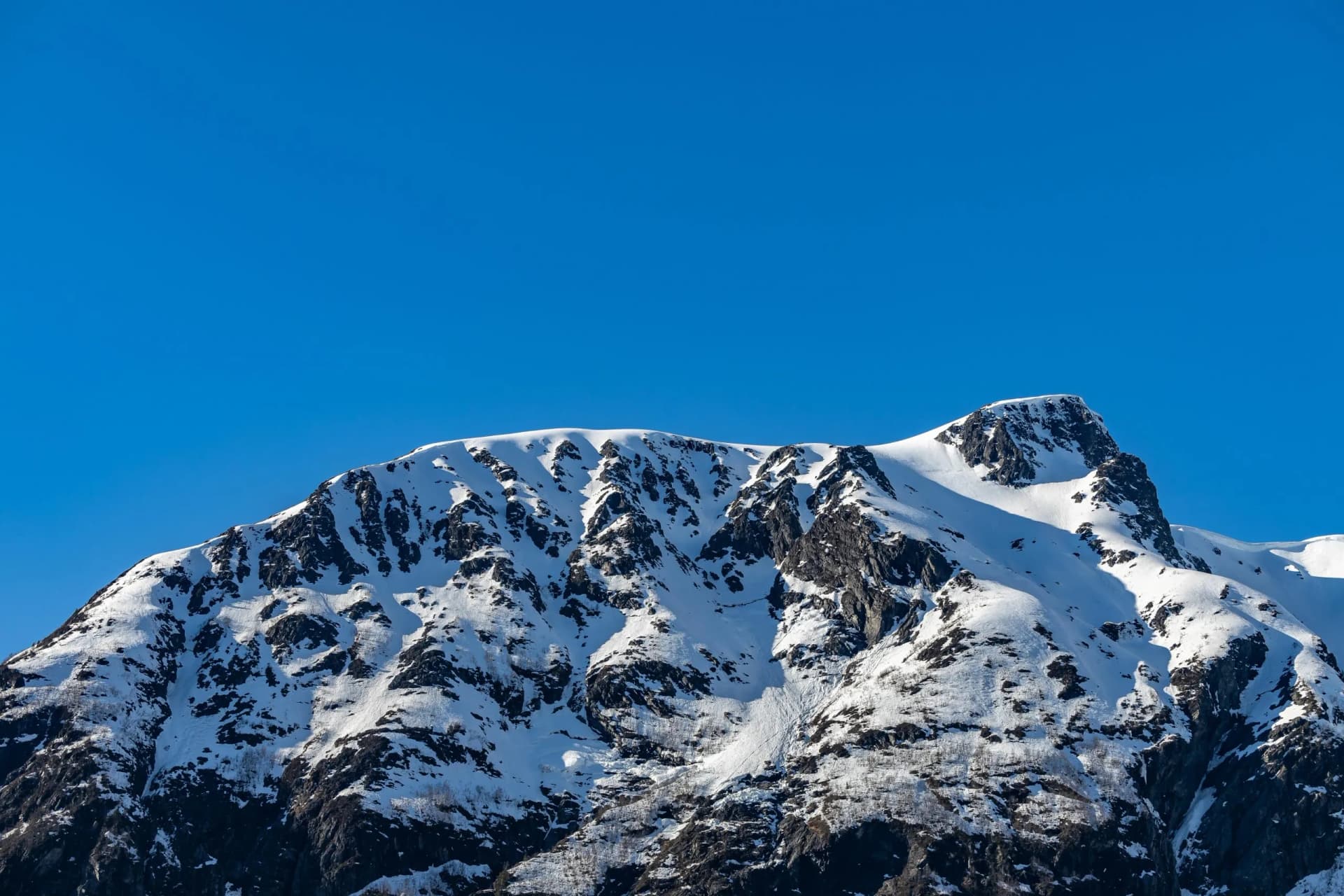Winter mountains covered in snow against the blue sky in Tresfjorden, Vestnes, Orskogfjellet